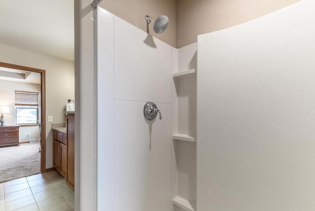 full bathroom with vanity, baseboards, walk in shower, and tile patterned floors