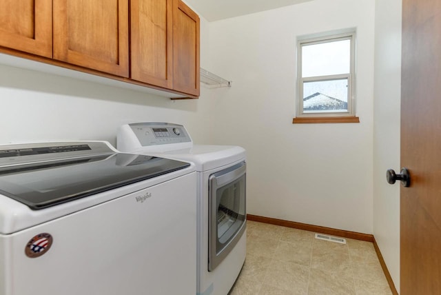 washroom with cabinet space, baseboards, visible vents, and washer and clothes dryer