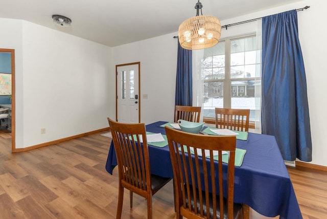 dining area with a notable chandelier, baseboards, and wood finished floors