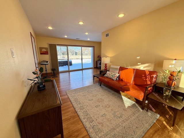 living room featuring wood finished floors, visible vents, and recessed lighting