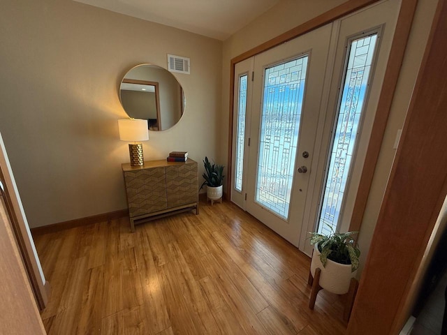 entryway featuring light wood-style flooring, visible vents, and baseboards