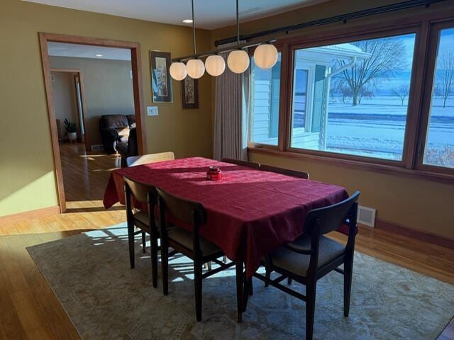 dining area with visible vents and wood finished floors