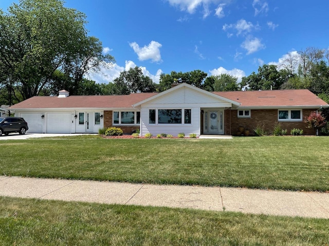 single story home featuring a garage, a front yard, brick siding, and driveway