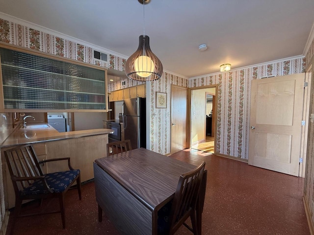 dining space featuring crown molding, visible vents, and wallpapered walls