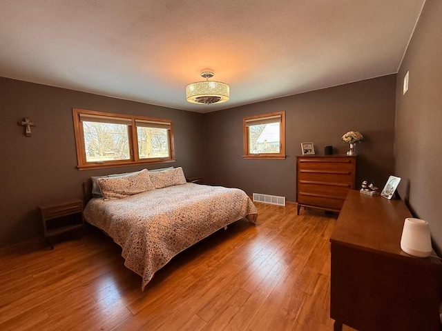 bedroom featuring visible vents and wood finished floors