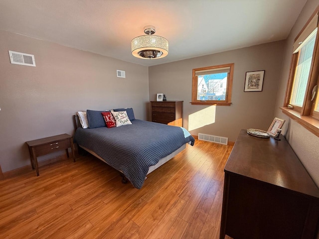 bedroom featuring light wood-style floors and visible vents