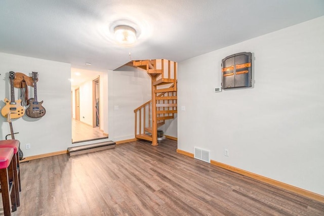 interior space featuring stairway, wood finished floors, visible vents, and baseboards