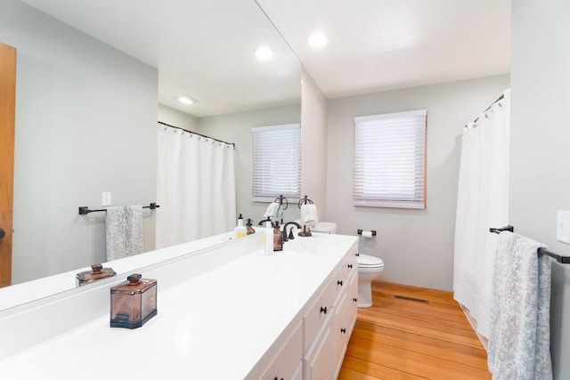 full bath with toilet, recessed lighting, wood finished floors, visible vents, and vanity