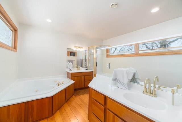 full bathroom featuring wood finished floors, two vanities, a sink, and recessed lighting