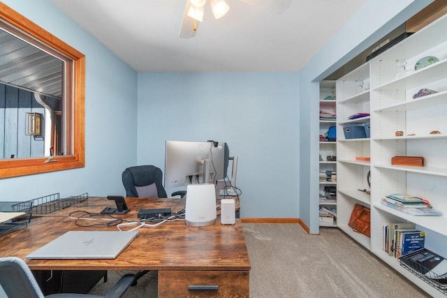 office area with baseboards, a ceiling fan, and light colored carpet