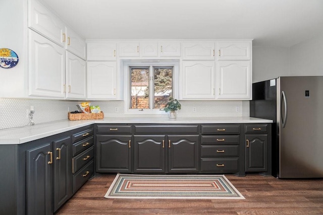 kitchen with dark wood-style floors, light countertops, freestanding refrigerator, and white cabinets