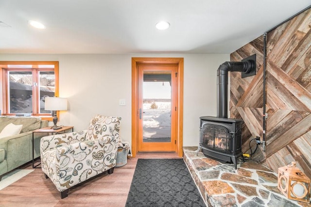 interior space with a wood stove, wood finished floors, and recessed lighting