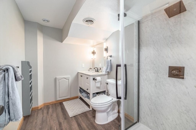 full bathroom with a stall shower, visible vents, toilet, wood finished floors, and vanity