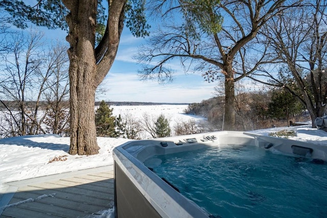 yard layered in snow with a wooden deck and a hot tub