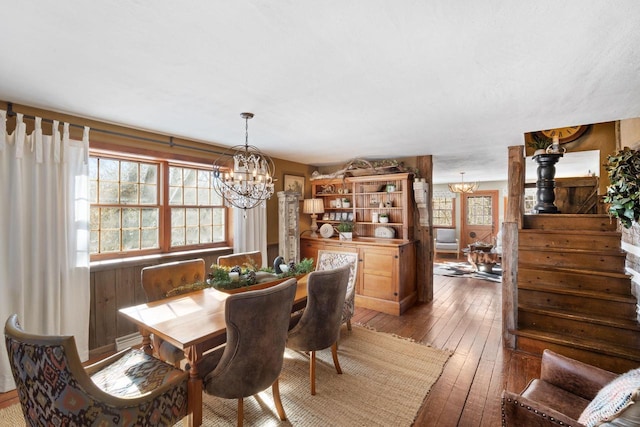 dining space featuring a chandelier, a wealth of natural light, and dark wood finished floors