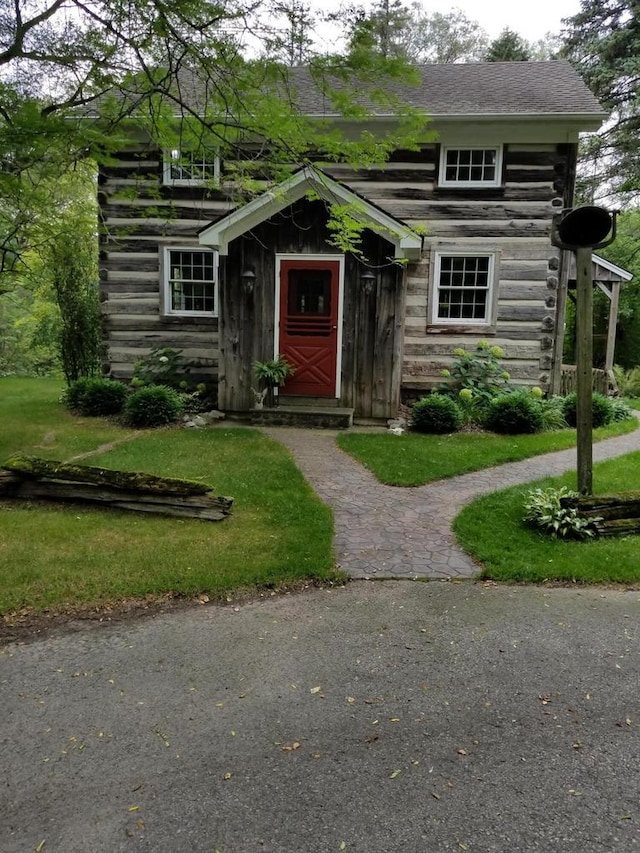 view of front of property with a front lawn and log siding