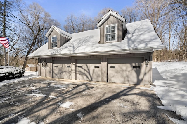 snow covered garage featuring a detached garage