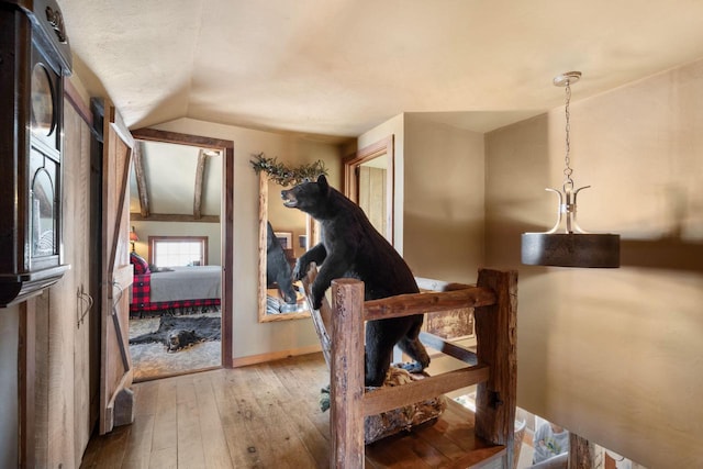 interior space with vaulted ceiling, wood finished floors, and baseboards