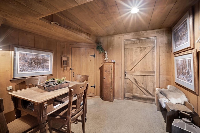 dining room with carpet, wood walls, and wooden ceiling