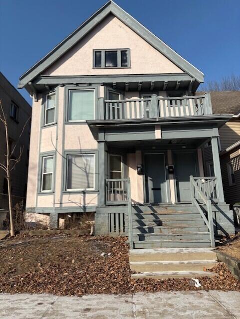 view of front of property featuring covered porch, a balcony, and stucco siding