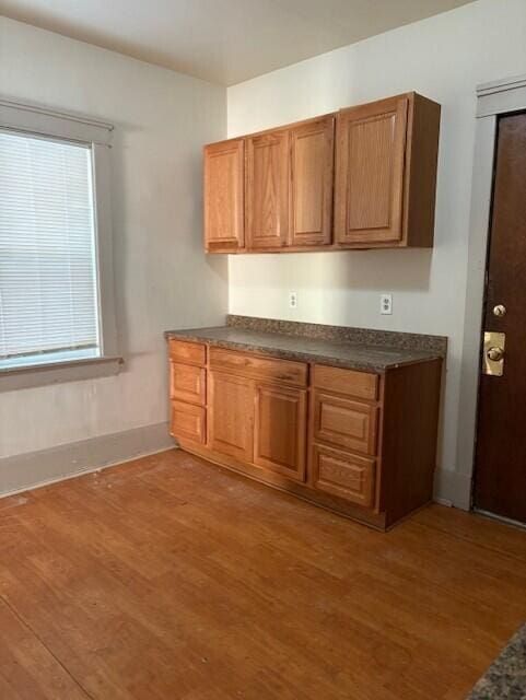 kitchen with dark countertops, brown cabinets, and wood finished floors