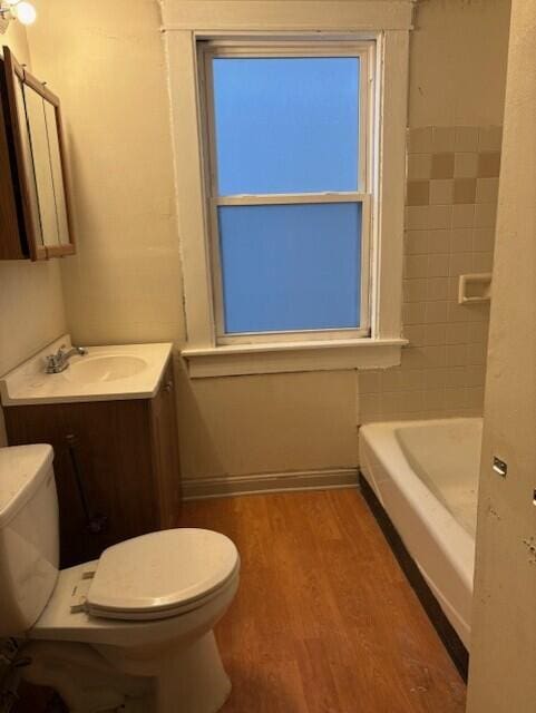 bathroom featuring baseboards, vanity, toilet, and wood finished floors