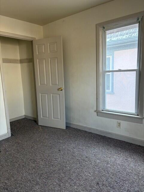 unfurnished bedroom featuring carpet and baseboards