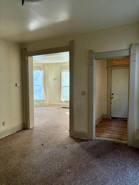 unfurnished room with carpet and baseboards