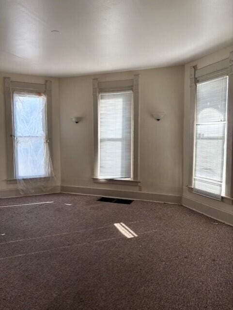 spare room featuring visible vents and baseboards