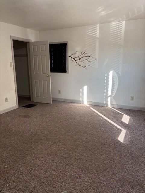 unfurnished room with carpet floors and baseboards