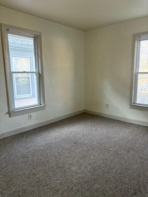 carpeted empty room with baseboards