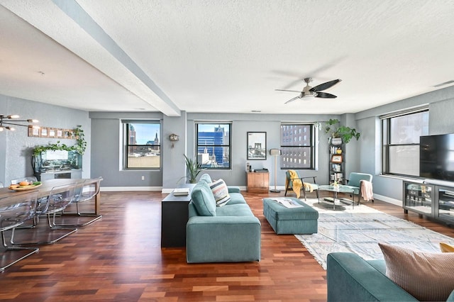 living area featuring ceiling fan, dark wood finished floors, and a textured ceiling