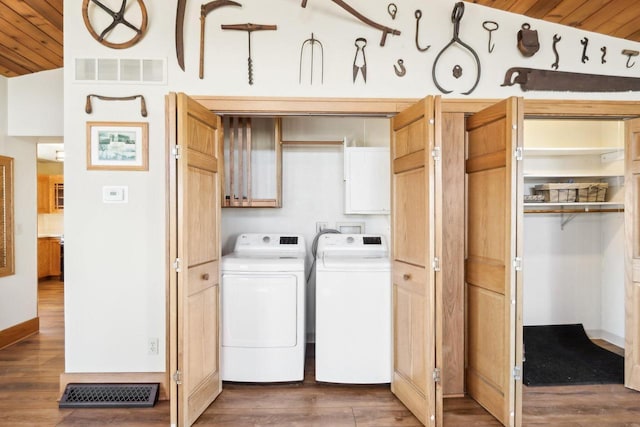 laundry area with visible vents, washing machine and dryer, cabinet space, and dark wood-style floors