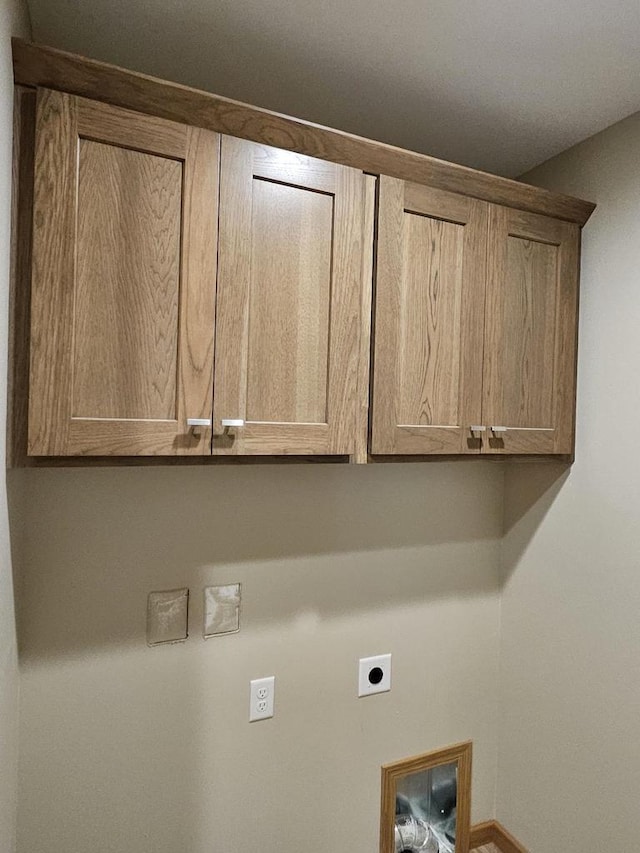 clothes washing area featuring cabinet space and electric dryer hookup