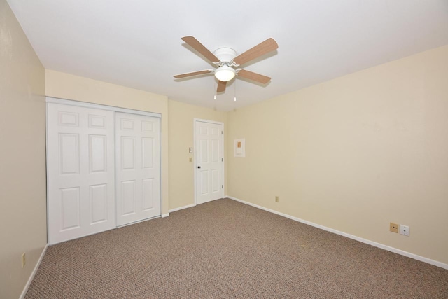 unfurnished bedroom with ceiling fan, a closet, carpet, and baseboards