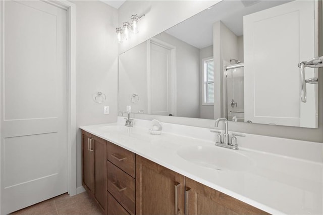 bathroom featuring double vanity, an enclosed shower, a sink, and tile patterned floors