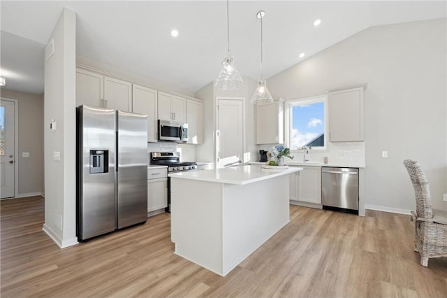 kitchen featuring light countertops, appliances with stainless steel finishes, white cabinetry, and a center island