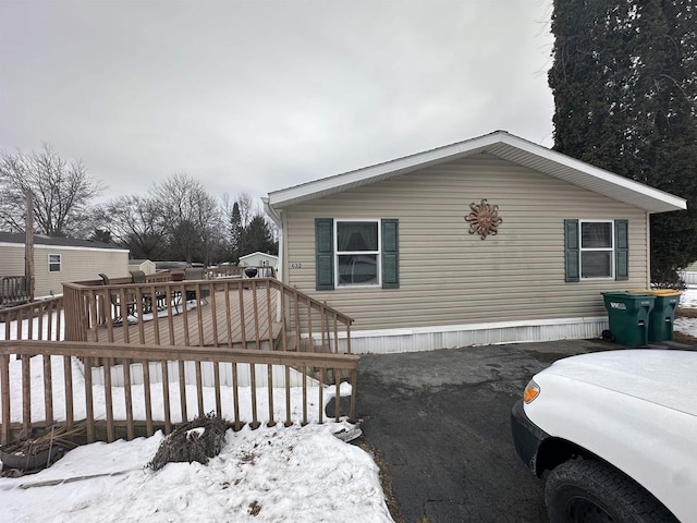 view of snowy exterior featuring a deck