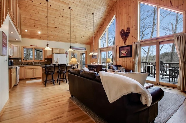 living room with wood ceiling, wood walls, plenty of natural light, and light wood-style flooring