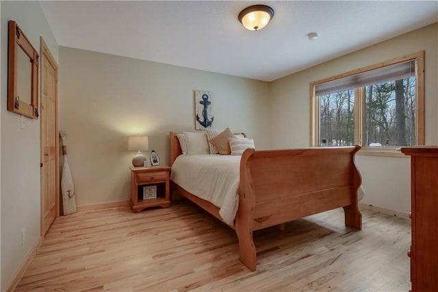 bedroom with light wood-type flooring and baseboards