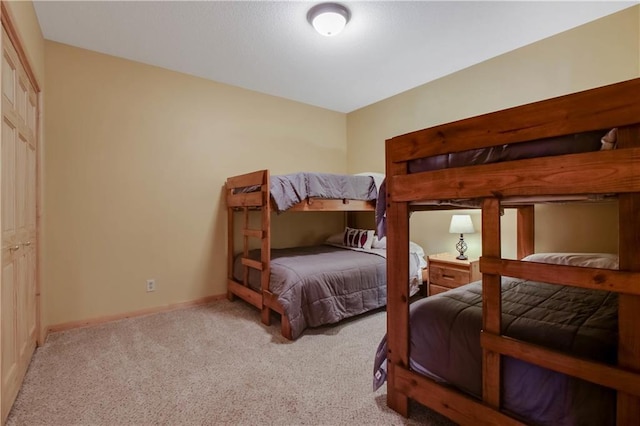 bedroom with baseboards and light colored carpet