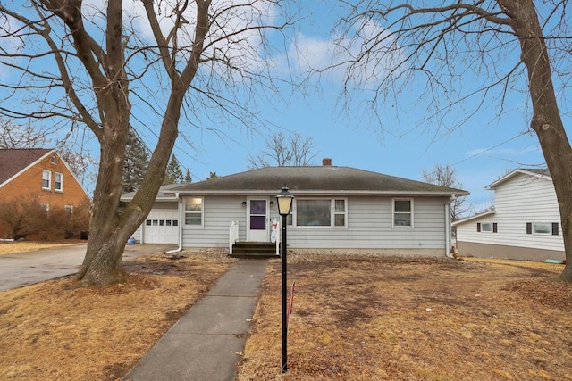 view of front of property featuring a garage, driveway, and a chimney