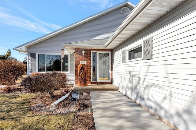 view of exterior entry featuring brick siding