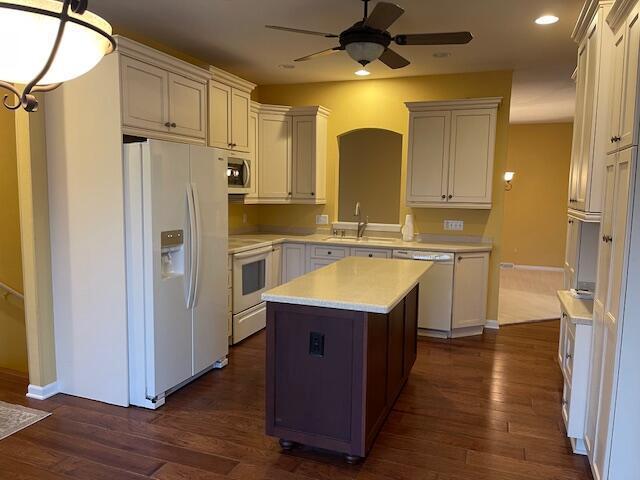 kitchen with dark wood finished floors, stainless steel appliances, a sink, and light countertops