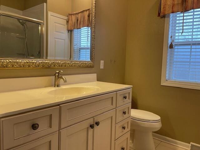 bathroom with tile patterned flooring, toilet, vanity, visible vents, and a stall shower