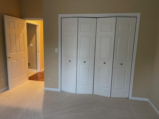 unfurnished bedroom featuring a closet, carpet flooring, and baseboards