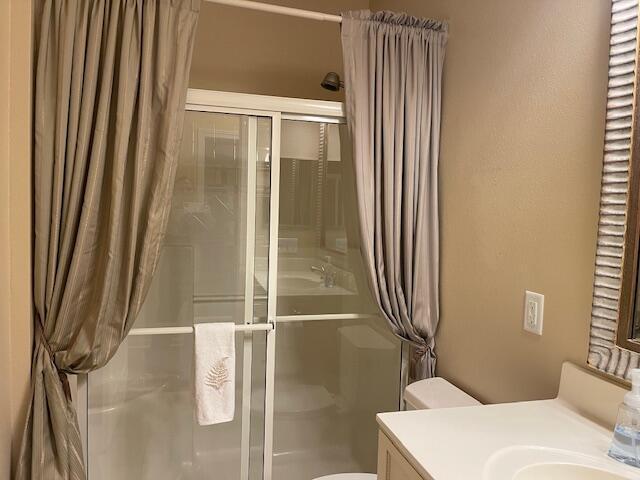 bathroom with vanity, a shower stall, and toilet