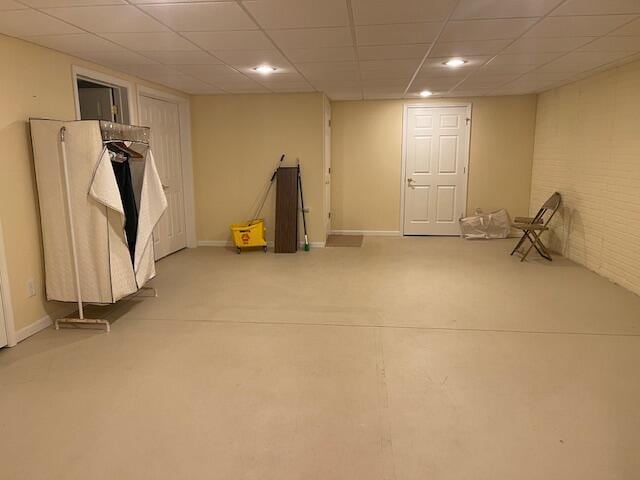 finished basement featuring baseboards, a drop ceiling, and recessed lighting