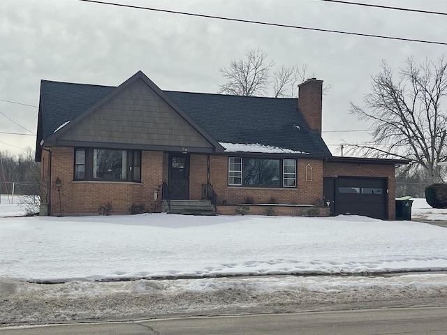 view of front of home with a garage, brick siding, and a chimney