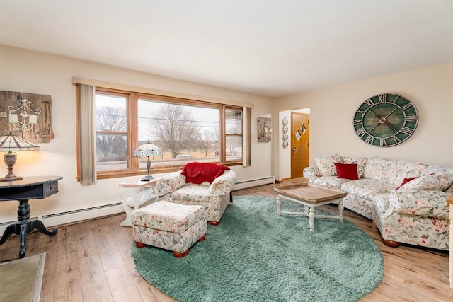 living area with a healthy amount of sunlight, a baseboard radiator, and wood finished floors